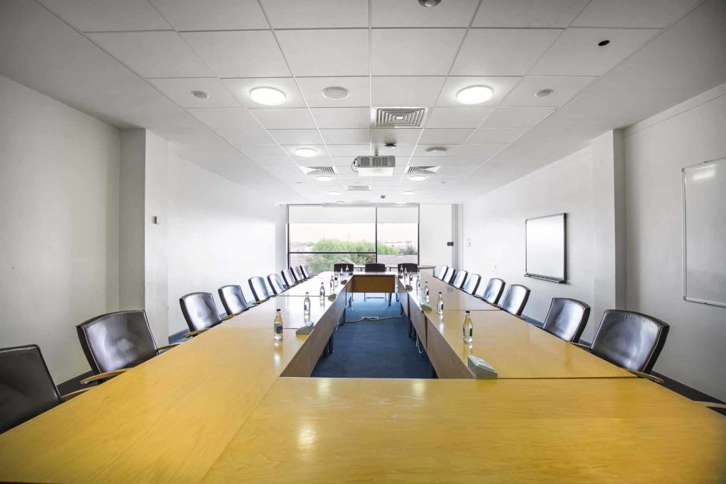 Bright board room with a long table and lots of seats.